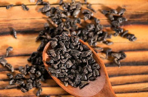 Dry puer tea leaf in wooden spoon on the rustick table