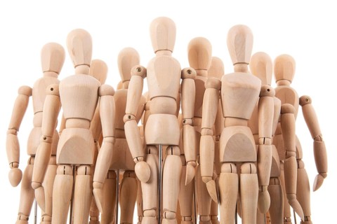 Many wooden mannequins isolated over white