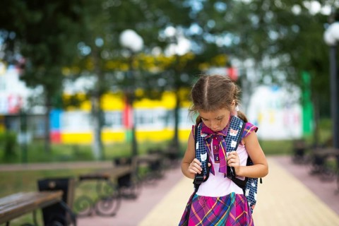 Sad, upset girl near the school with a backpack. Fatigue from classes, resentment, lessons not