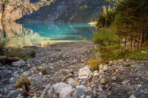 Oeschinensee lake in Switzerland in autumn, landscape photography, crystalic blue water, trees