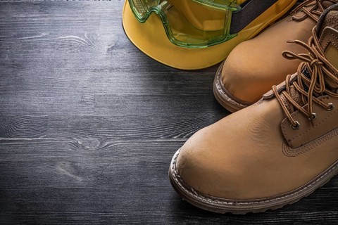Protective spectacles building helmet safety boots on wooden board