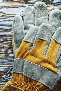 Protective gloves on wooden board top view
