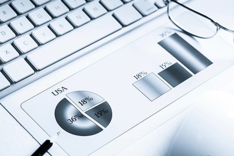 Business workplace with keyboard mouse and papers with graphs and diagrams