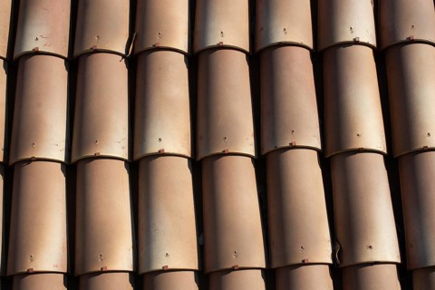 Tiles on old castle roof, architecture background. Brown roof tiles