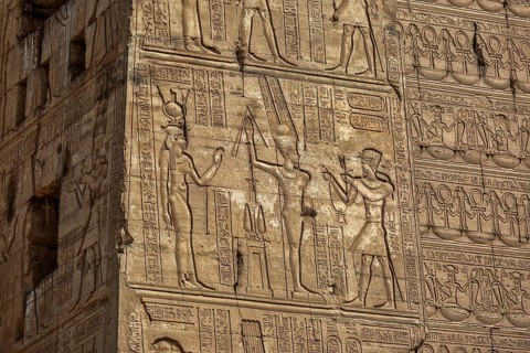 Hieroglyphic carvings on the exterior walls of an ancient egyptian temple