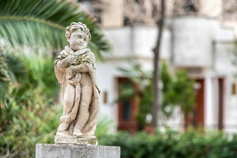 Baroque sculpture of a child in a park in Trani, Southern Italy