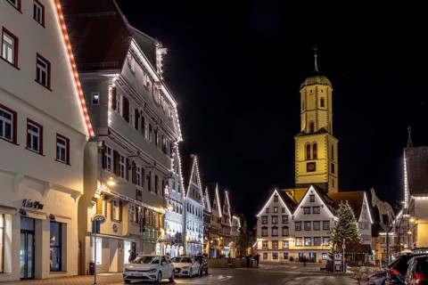 Night photo of historic buildings around the market square with Christmas tree and Christmas lights
