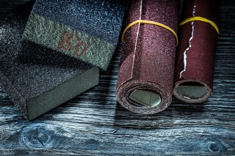 Rolled abrasive paper blocks on vintage wooden board