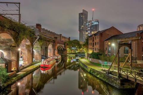 Castlefield in Manchester, Great Britain, at night, with a modern skyscraper in the background
