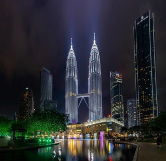 A picture of the Petronas Twin Towers, the KLCC Park water and light fountain show and the Suria