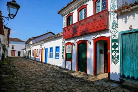 Typical cobblestone street with decorative and colorful colonial buildings in late afternoon light