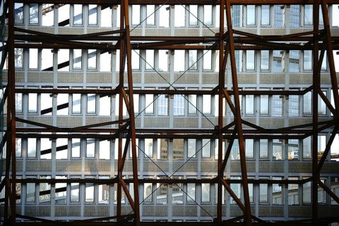 A heavy iron construction supports a single wall of a demolished tower block