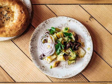 Authentic shot of georgian style salad with red beans, potatoes, salted cucumber on rustic wooden