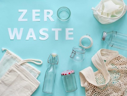 Zero waste concept. Textile eco bags, glass jar and bottle on blue background with Zero Waste white