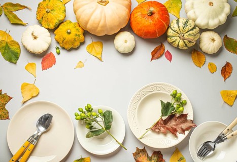 Thanksgiving festive table composition with different colourful pumpkins, autumn leaves, empty