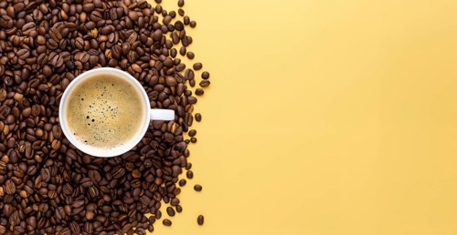 International coffee day, a cup of Arabica coffee beans on a yellow background