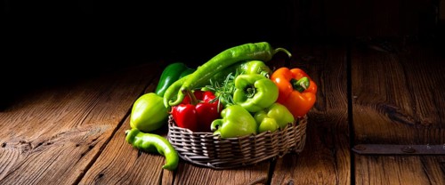 Various harvested peppers and hot peppers in basket