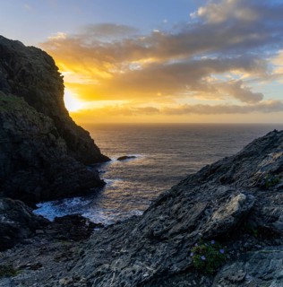 Long exposure sunset seascape with rocks and reef at Capo Falcone in Sardinia