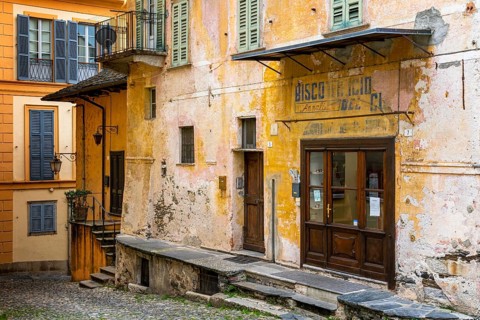 Orta San Giulio, Italy, 13 March, 2023: colorful shabby buildings in the old town center of Orta