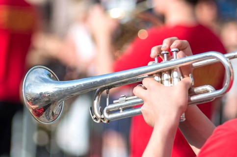 A jazz trumpeter plays of his trumpet in the brass band during a carnival live event. Blurry close
