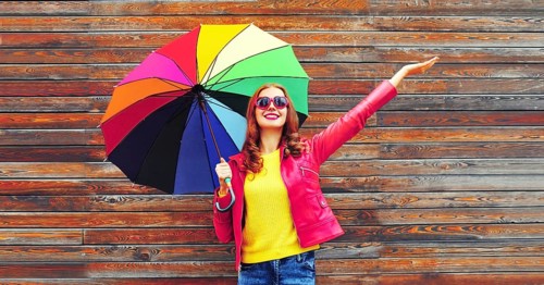 Autumn portrait of happy smiling young woman holding colorful umbrella wearing red jacket, heart