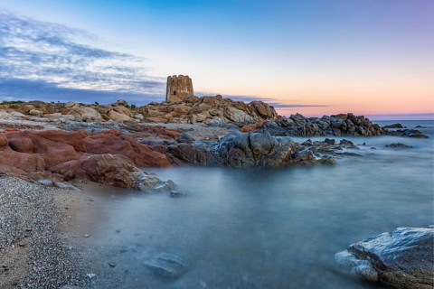 Old historic tower from the 16th century and rocks at sunset on the beach, long exposure, Torre di