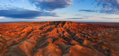 Aerial panorama of textural colorful striped canyons Tsagaan suvarga, White stupa at sunrise.