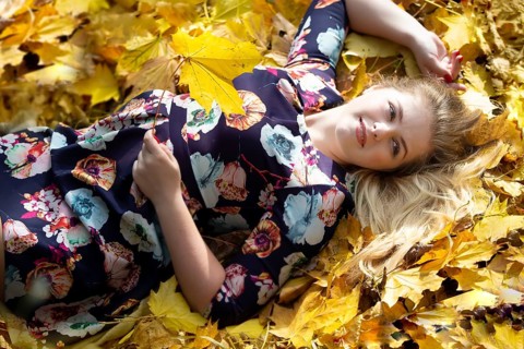 A beautiful girl lies in the autumn leaves