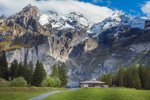 Oeschinnensee lake, wooden chalet and Swiss Alps, Bernese Oberland, Switzerland panorama
