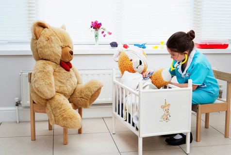 Caucasian girl nursing her teddy bear themes of daydreaming imagination ambition