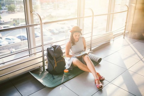 Waiting, delayed transport in the terminal of the airport or train station. Young caucasian woman