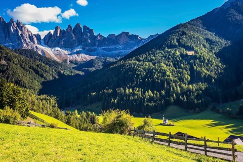 Picturesque little church of Santa Maddalena in valley Val di Funes. Sunny day in Dolomites, Tirol.