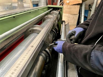 Technician worker placing the blades of a machine to cut steel coils. Industrial environment and