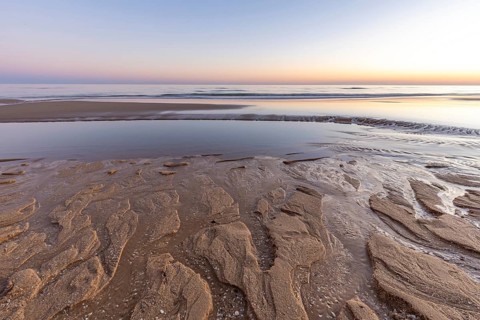 What a sandy beach on the Atlantic. Landscape shot at sunset on a coast with sandstone cliffs. Low