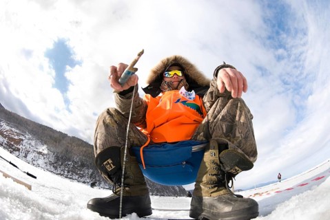 UST-BARGUZIN, RUSSIA - APRIL 11: A fisher sits with a rod at an ice hole during the 5th Annual