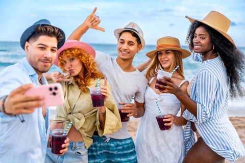 Group of cheerful young multi ethnic friends in summer clothes taking selfie with smartphone and