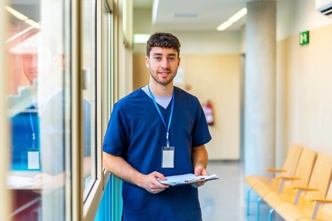 Portrait of a confident male nurse reviewing patient files, showcasing professionalism and