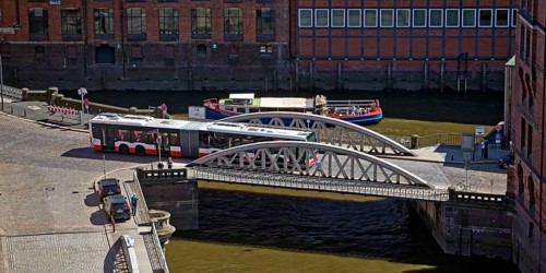 An articulated bus on the small Pickhuben bridge and a ship on Brooksfleet seen from above,