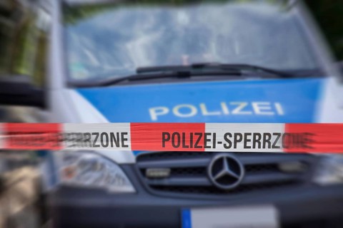 (Photomontage) Symbolic image of a police operation: police cordon in front of an emergency vehicle