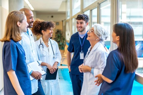 Doctors and nurses sharing a friendly moment, talking and smiling together in a hospital corridor