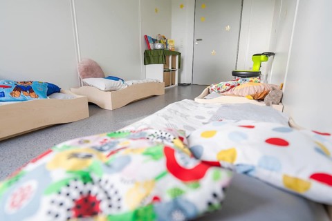 Cosy children's bedroom with beds, colourful cushions and toys, transitional daycare centre in