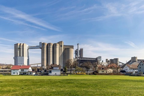SCHWENK cement works in Heidenheim-Mergelstetten. In front, residential buildings with an idyllic