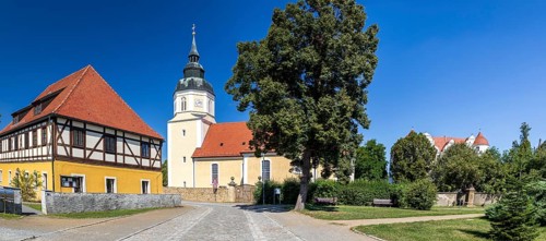 St George's Church and moated castle, Großkmehlen village square, Ortrand, Brandenburg, Germany