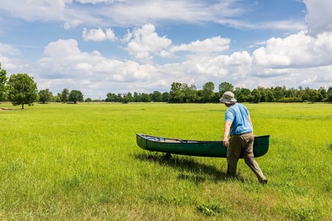 Man transferring a canoe, Große Röder near Wildenhain, Großenhain, Saxony, Germany