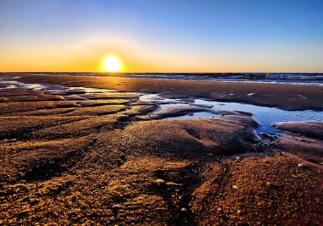 Atmospheric sunrise over the mudflats with the North Sea, Wyk auf Föhr, North Frisia,