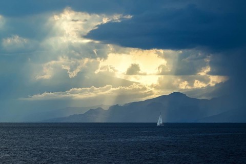 Sun rays in the clouds over Sicily, Tyrrhenian Sea, Italy
