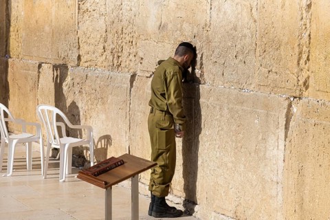 Jerusalem, Israel, 15 April, 2022: Israeli soldier praying in front of Sacred Western Wall in