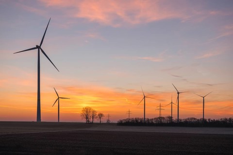 Wind farm at sunset, the sky is bathed in soft pink and orange, near Ulm, Swabian Alb,