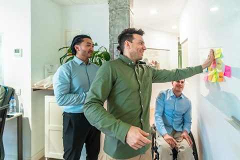 Business colleagues discussing ideas written on sticky notes during a productive meeting in a