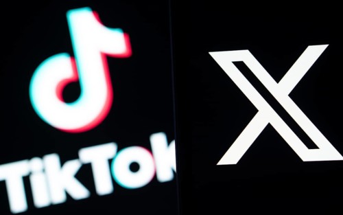Twitter (X) logo is seen on a smartphone and Tiktok logo in the background